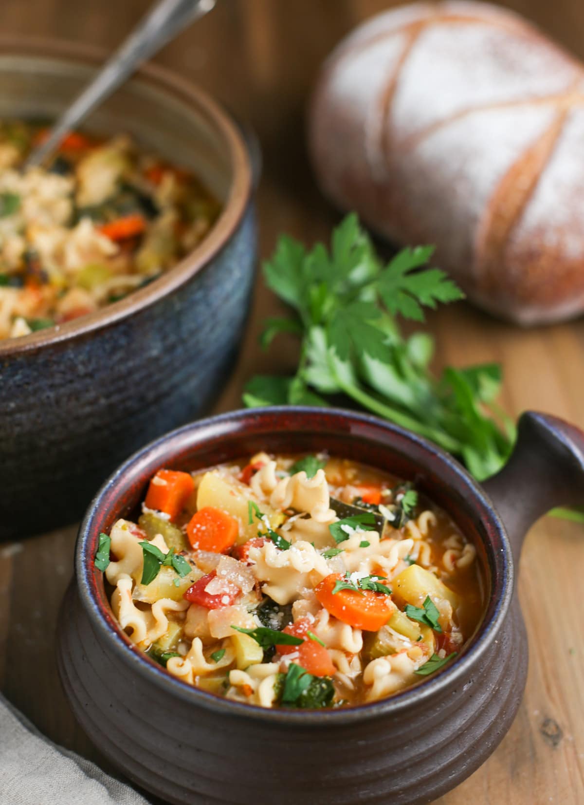 Small bowl of Mighty Minestrone Soup with Loaf of Bread