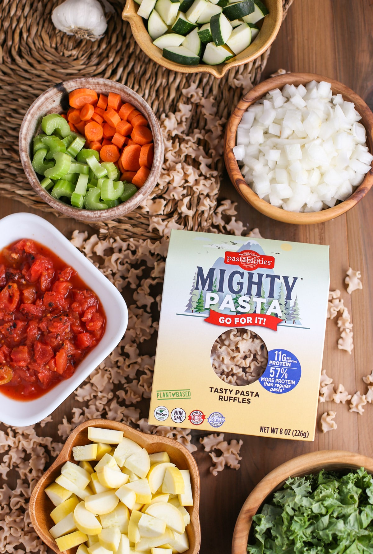 Mighty Minestrone Soup ingredients in bowls alongside Mighty Pasta box