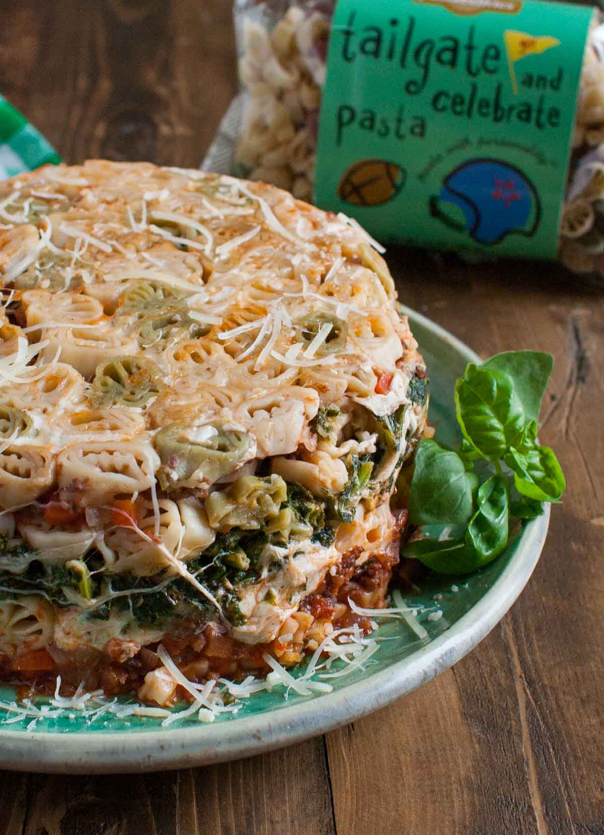 Tailgate Timballo | WorldofPastabilities.com | Nine layers of fabulous flavors: meat sauce, kale bechamel, fresh cheeses, and pasta. Serve slices during the big games and WOW your guests! Fun with any shaped pasta!