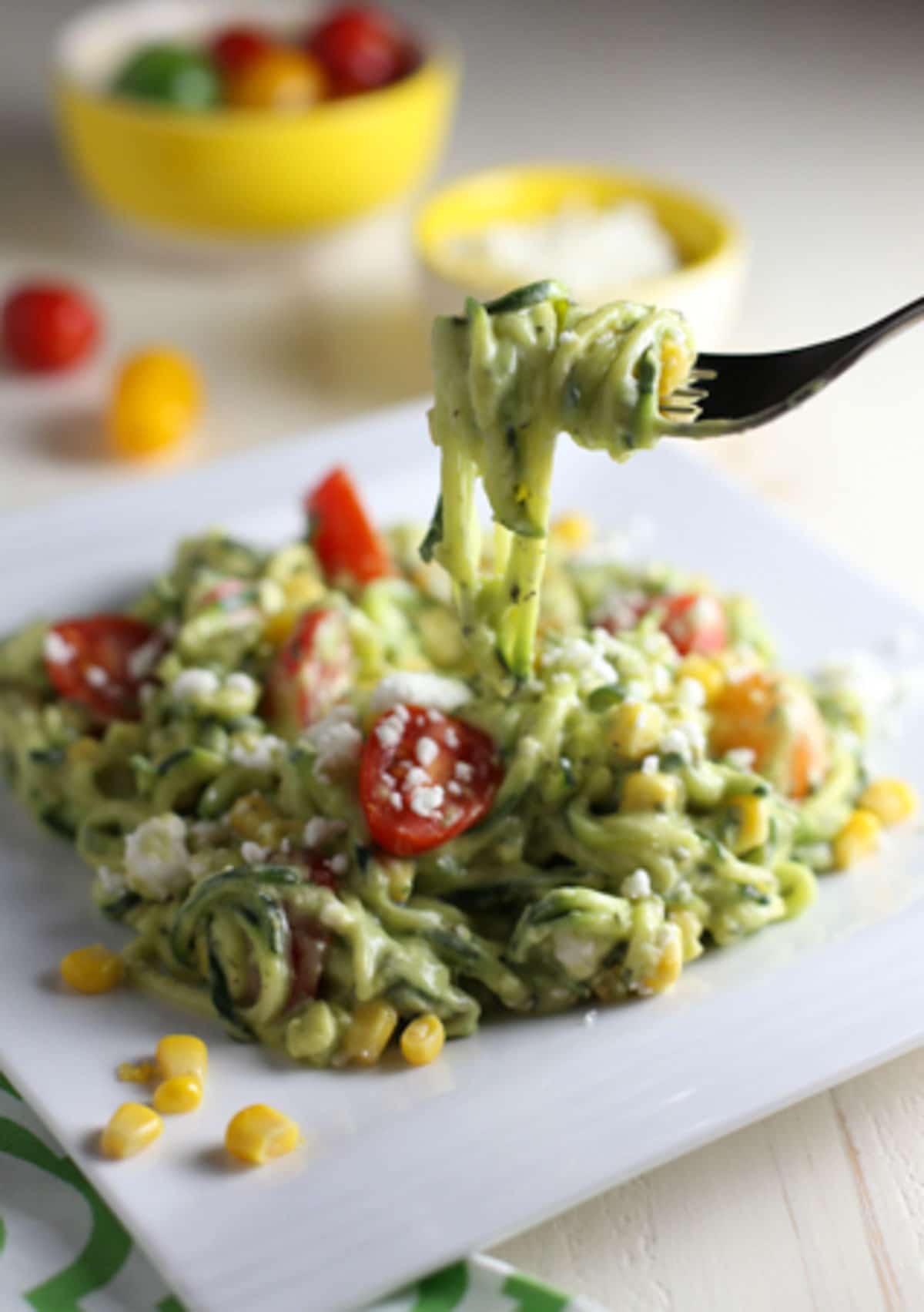 Zucchini Noodle Salad with Tomatoes, Goat Cheese, Corn & Avocado Sauce | WorldofPastabilities.com | Healthy, fresh, and delicious noodles that will convince even the kids it is pasta! The avocado sauce is the star...perfect side for any grilled meats this spring and summer!